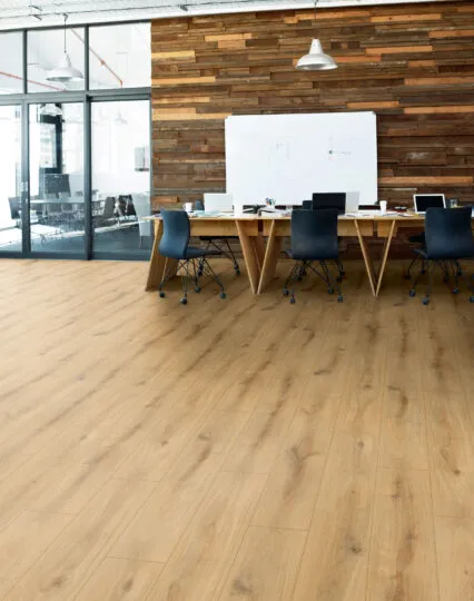 Modernes Büro mit Holzfußboden und großer Holzwand, Konferenztisch mit schwarzen Stühlen, Laptops und Büromaterialien, große Fenster und Deckenlampen.
